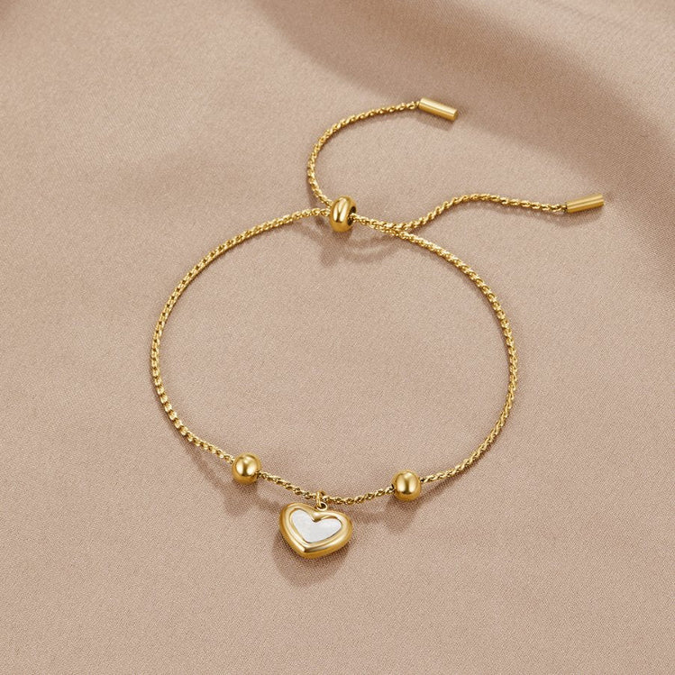 Forever Love Heart Bracelet, laid flat on beige satin, heart charm with white centre