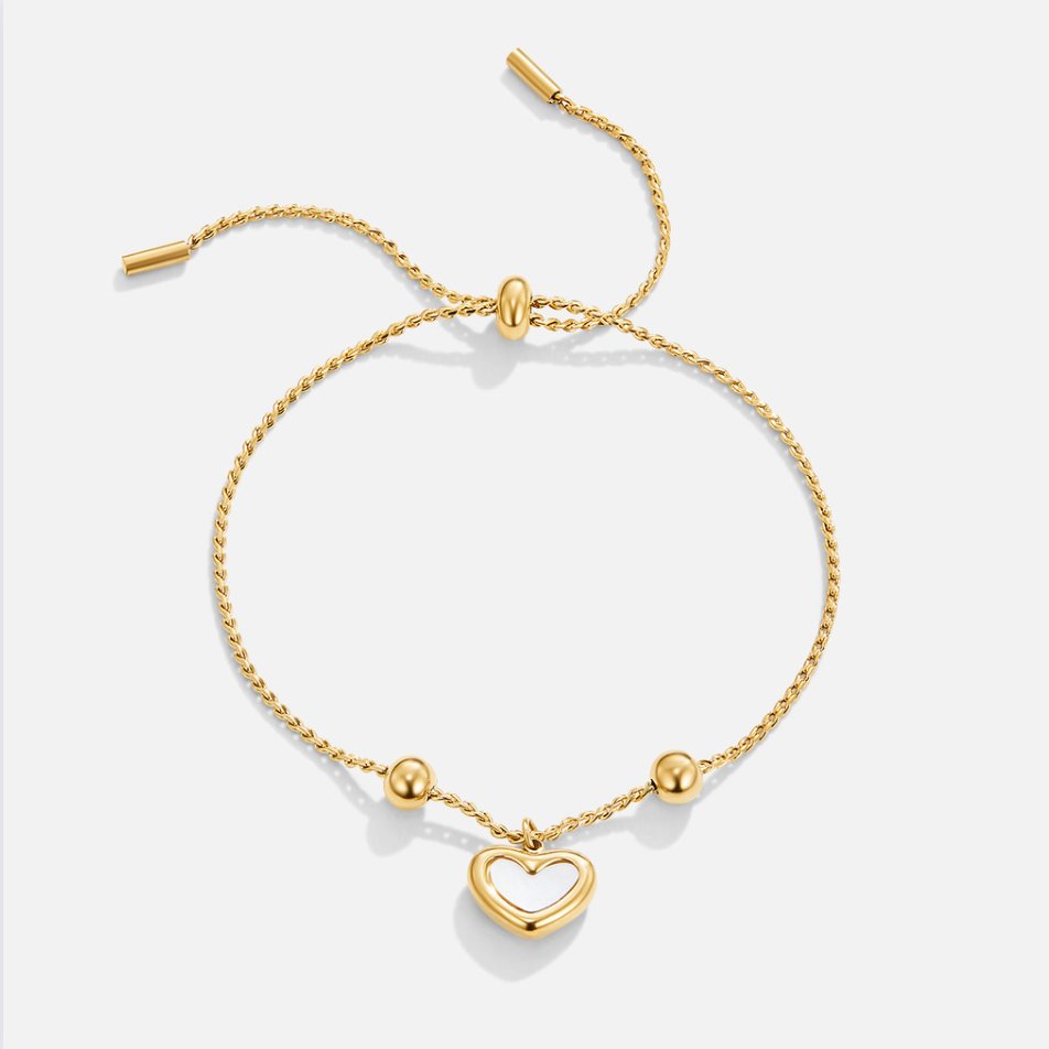 Forever Love Heart Bracelet, flat lay of gold chain bracelet with heart charm on white