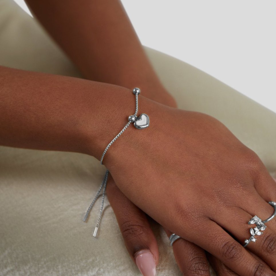 Forever Love Heart Bracelet, worn on a wrist with a silver heart charm and sliding bead clasp