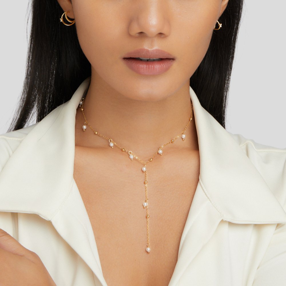Lariat Pearl Drop Necklace, worn on a model in a white collared top, with pearl drops