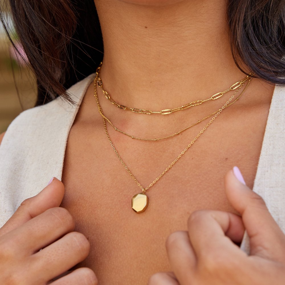 Geometric Pendant Necklace, worn layered at the neck with a faceted gold pendant
