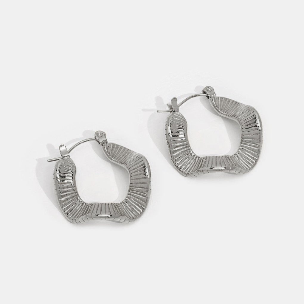 Geometric Wave Silver Hoop Earrings, a pair of silver hoops on a plain white background
