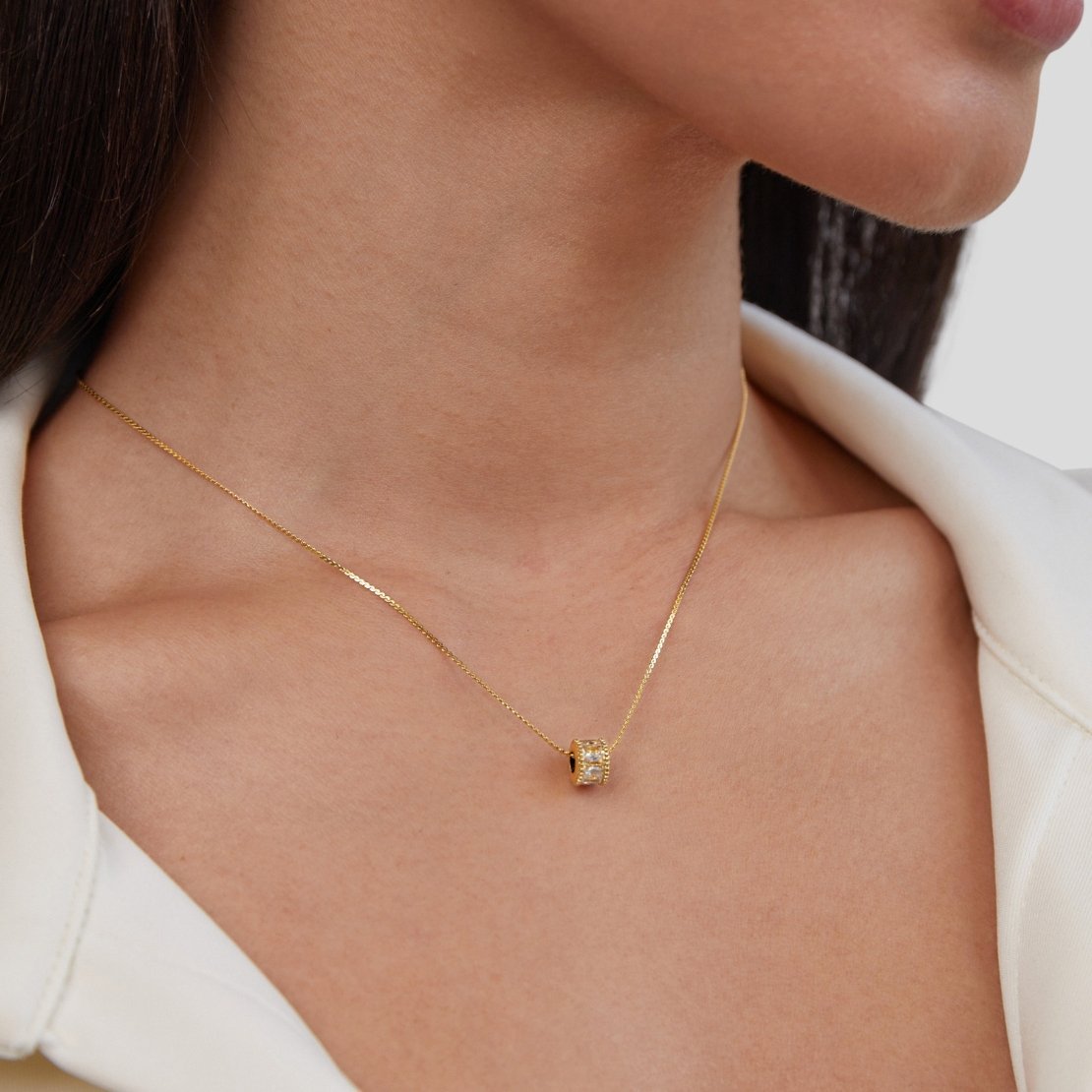 Gigi 18K Gold Set, worn on a neck with a white collared top, close-up on the pendant