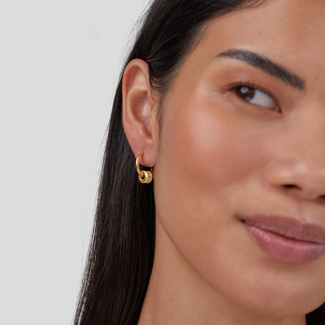 Gigi Crystal 18K Gold Hoop Earrings, worn in one ear on a model with long dark hair, gold hoop