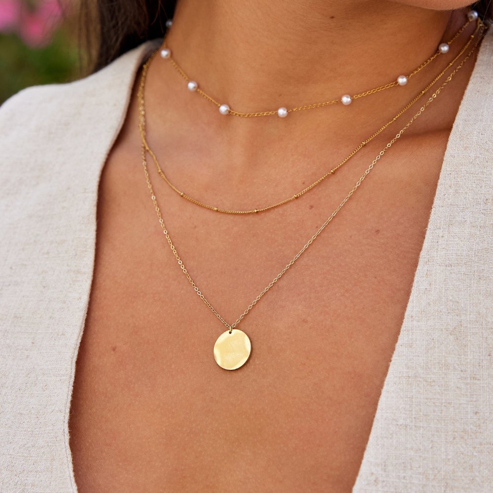 Gold Coin Necklace, worn layered at the neck with pearl and beaded chains, gold disc pendant