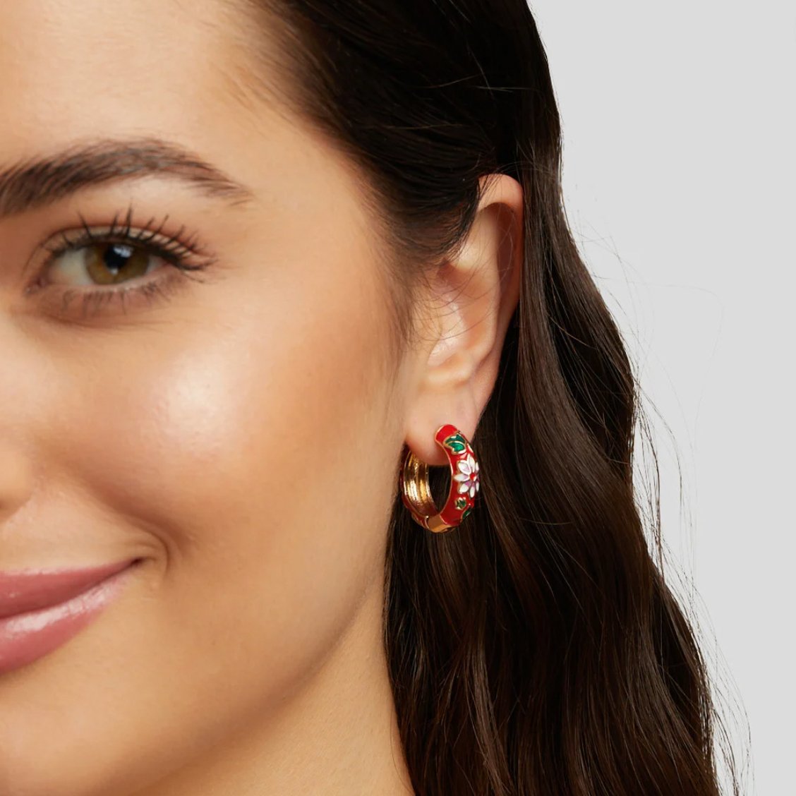 Gold Hoop Flower Earrings, worn in an ear, red enamel with white flowers and green leaves