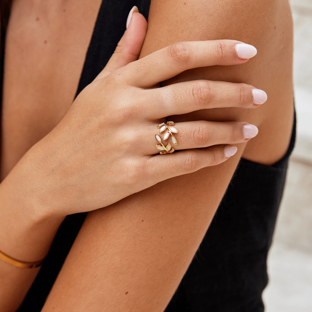Gold Leaf Ring, worn on a hand with pale pink nails, leaf-shaped white stones