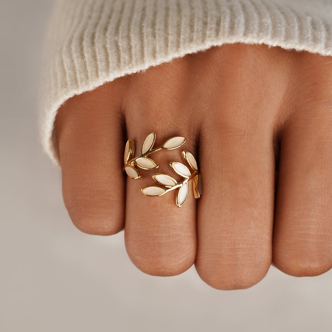 Gold Leaf Ring, worn on a finger with a cream knit sleeve behind it