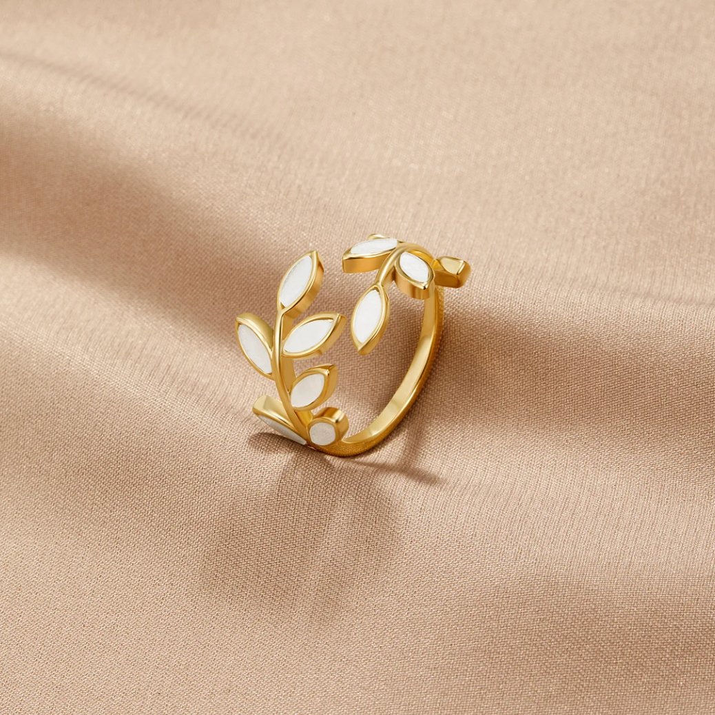 Gold Leaf Ring, lying on beige satin, gold vine with white enamel leaves