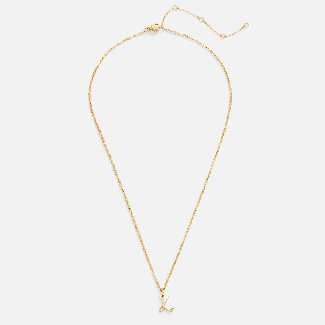 Gold Letter Heart Necklace, flat lay of a gold chain necklace with a script letter pendant
