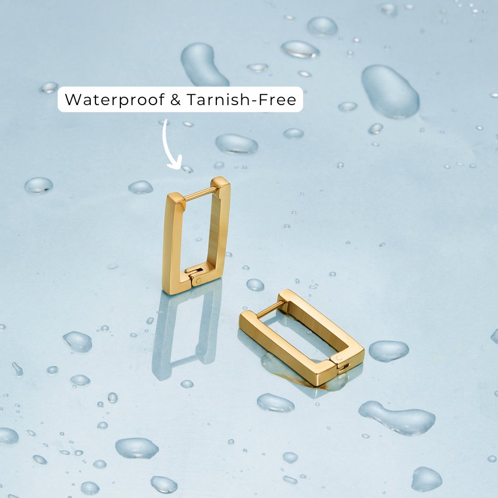 Gold Rectangle Hoop Earrings, two gold rectangular hoop earrings standing on wet blue surface