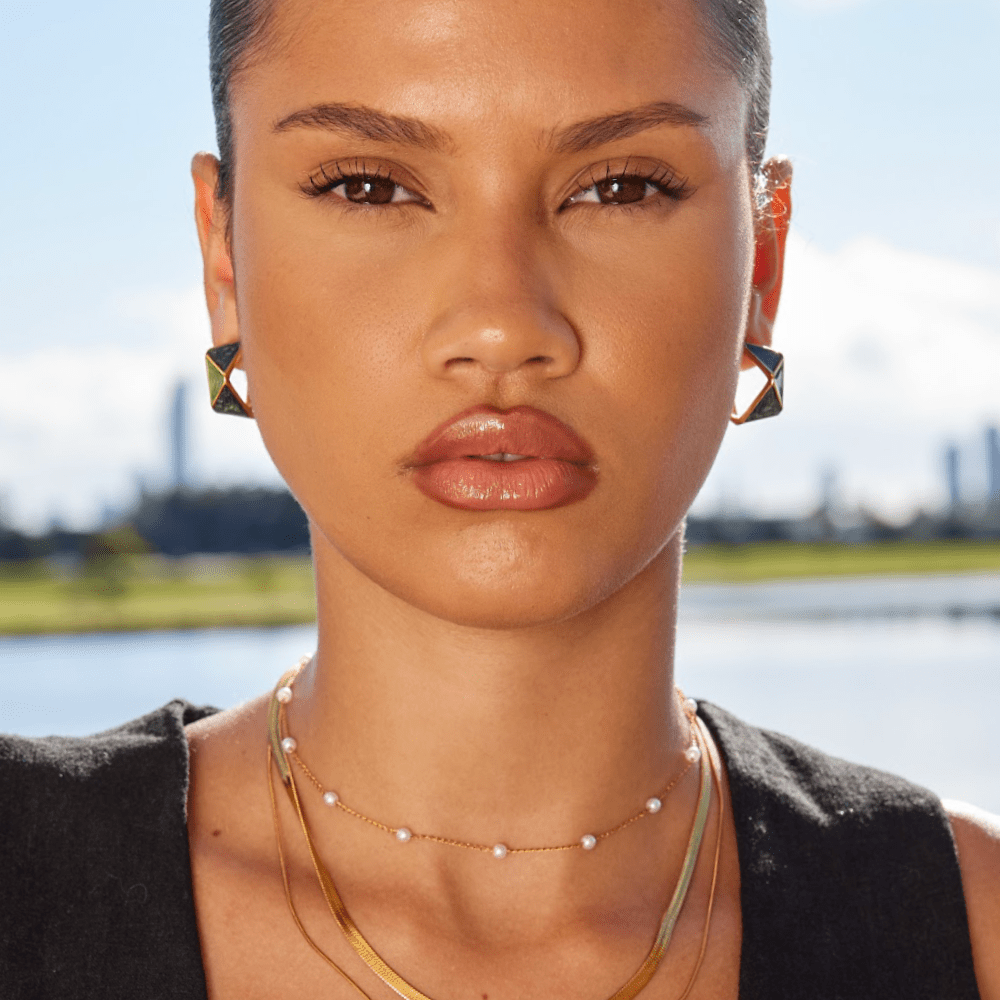 Green Atlantis Hoop Earrings, worn on a model with pearl and gold layered necklaces