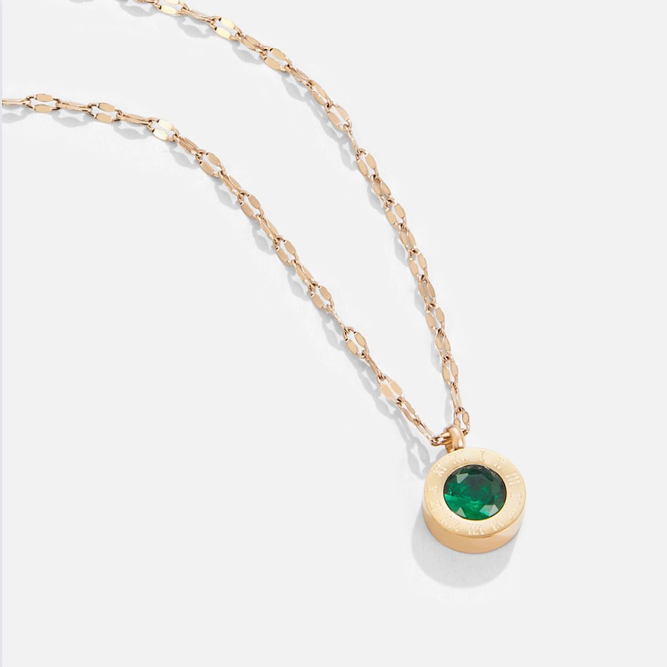 Green Crystal Athena Necklace, flat-lay of a gold chain with a round green-stone pendant on white