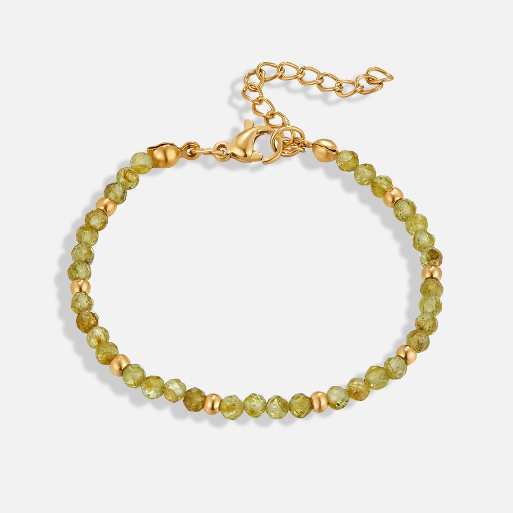 Green Peridot Bead Bracelet, flat lay of a bracelet with faceted green beads, gold spacers and clasp