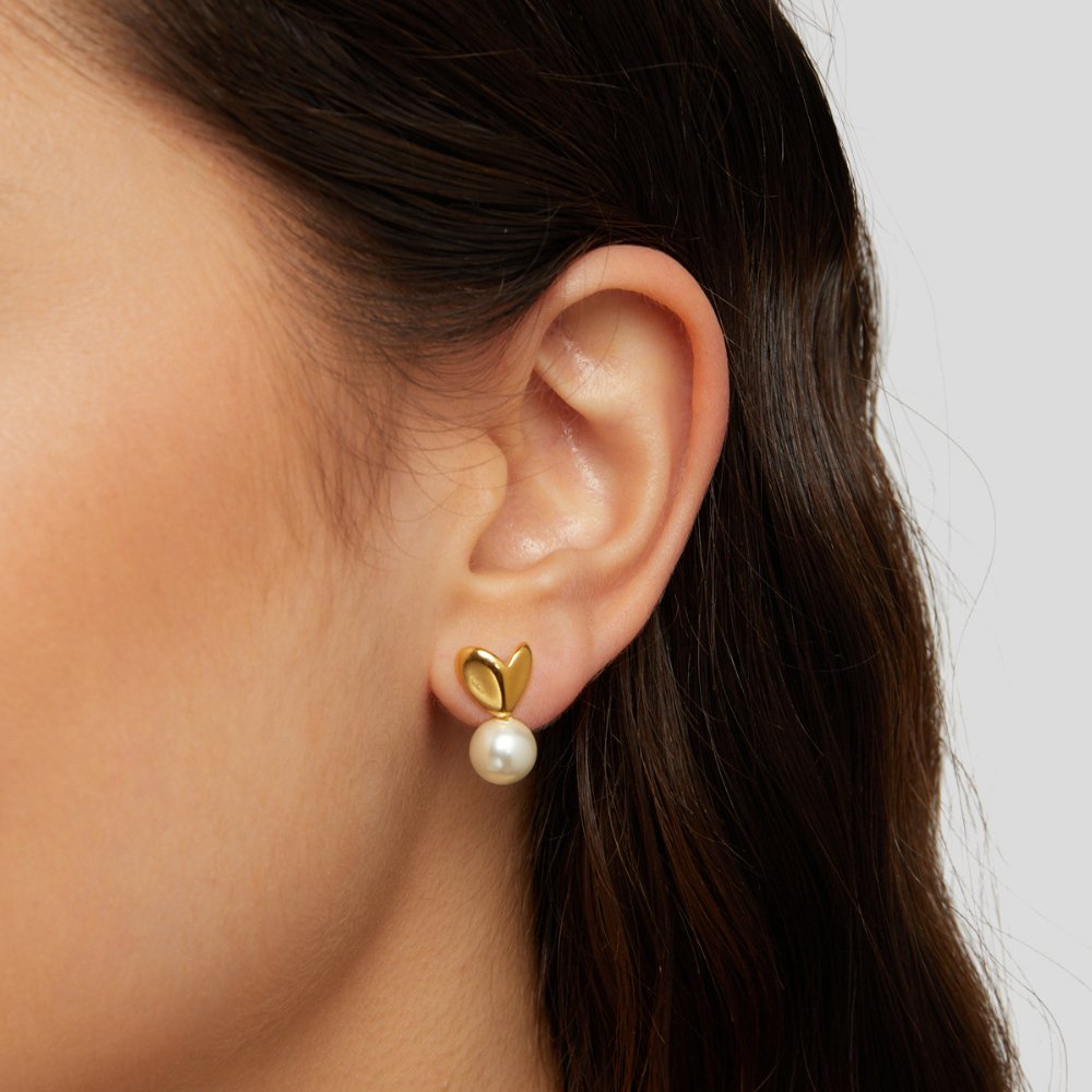 Heart & Pearl Earrings, worn on an ear, gold heart stud with a pearl drop