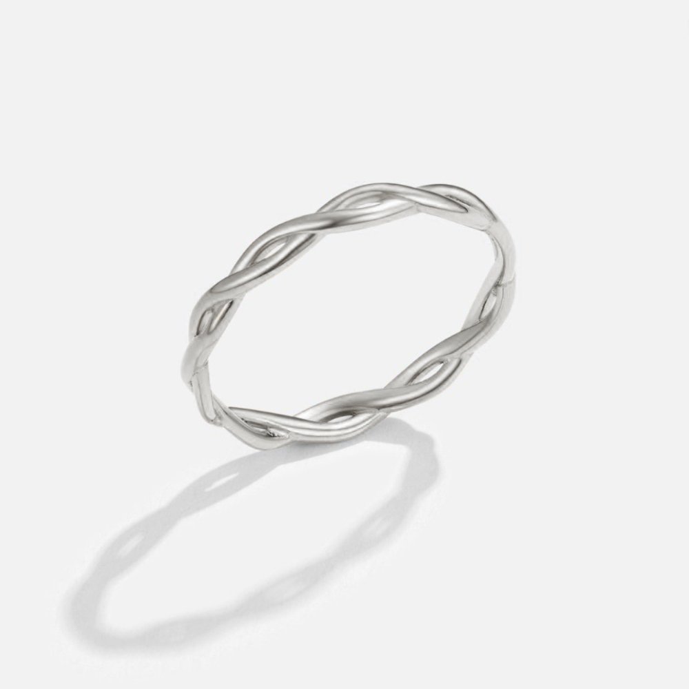 Infinity 18K Silver Twist Ring, standing upright on a light grey surface, braided silver band
