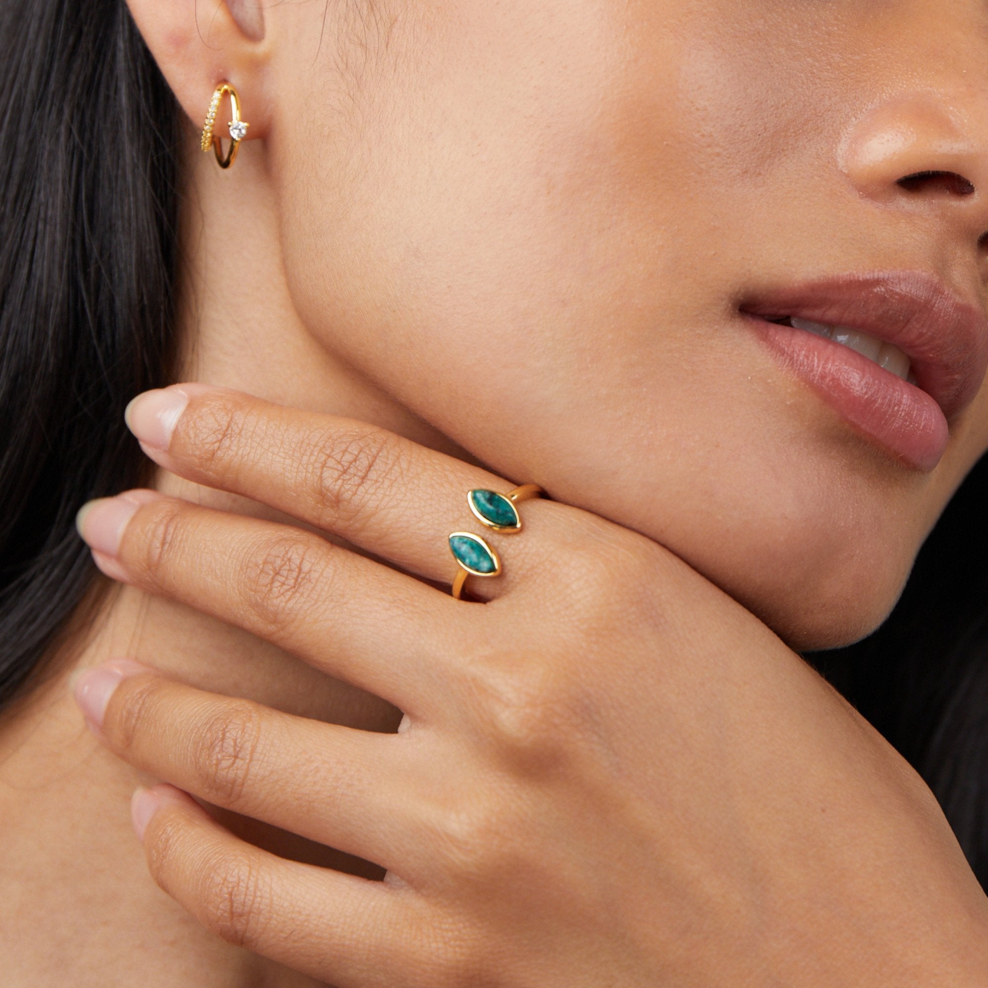Jade Green Wrap Ring, worn on a hand against a neck, with gold hoop earring