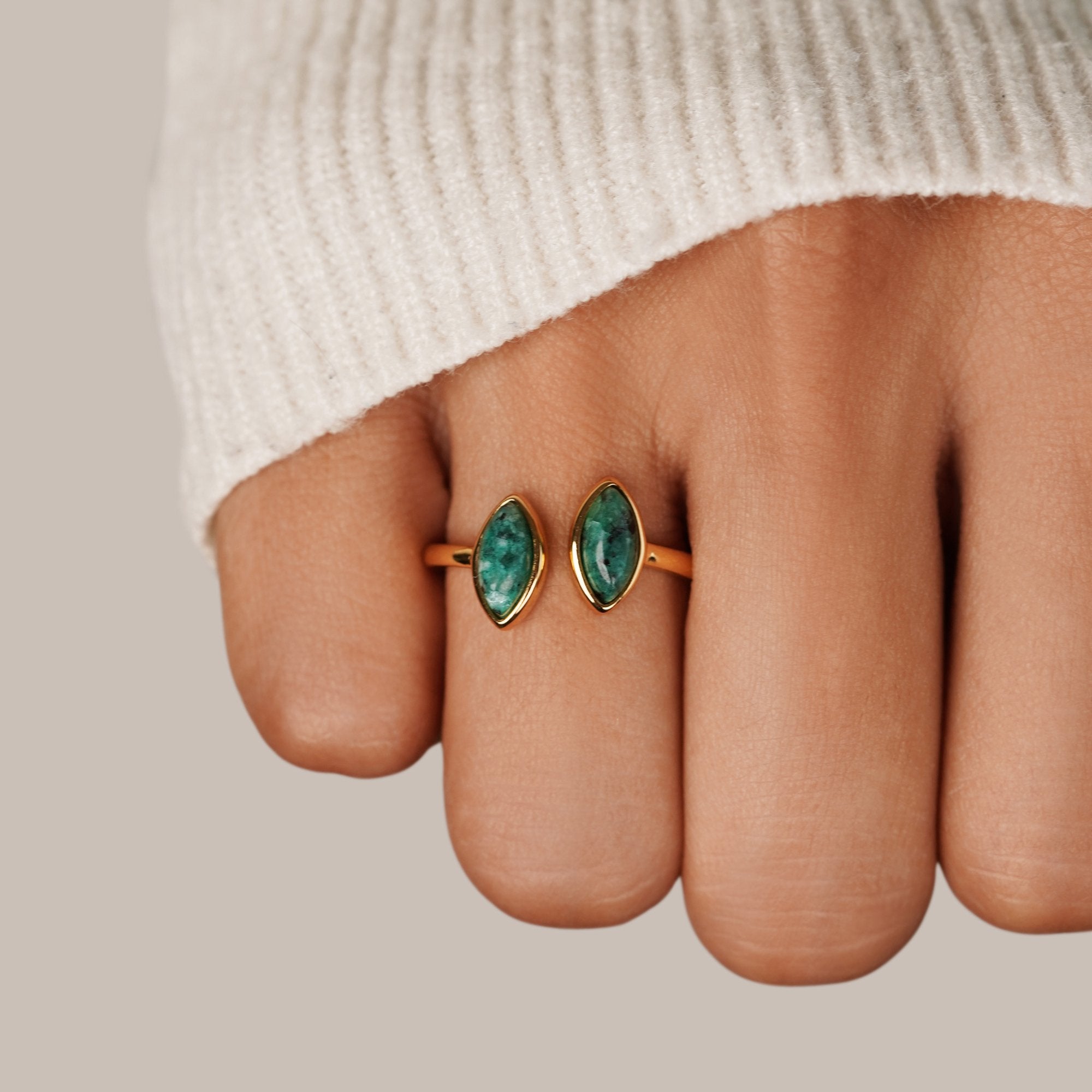 Jade Green Wrap Ring, worn on a finger with a white knit sleeve, gold setting