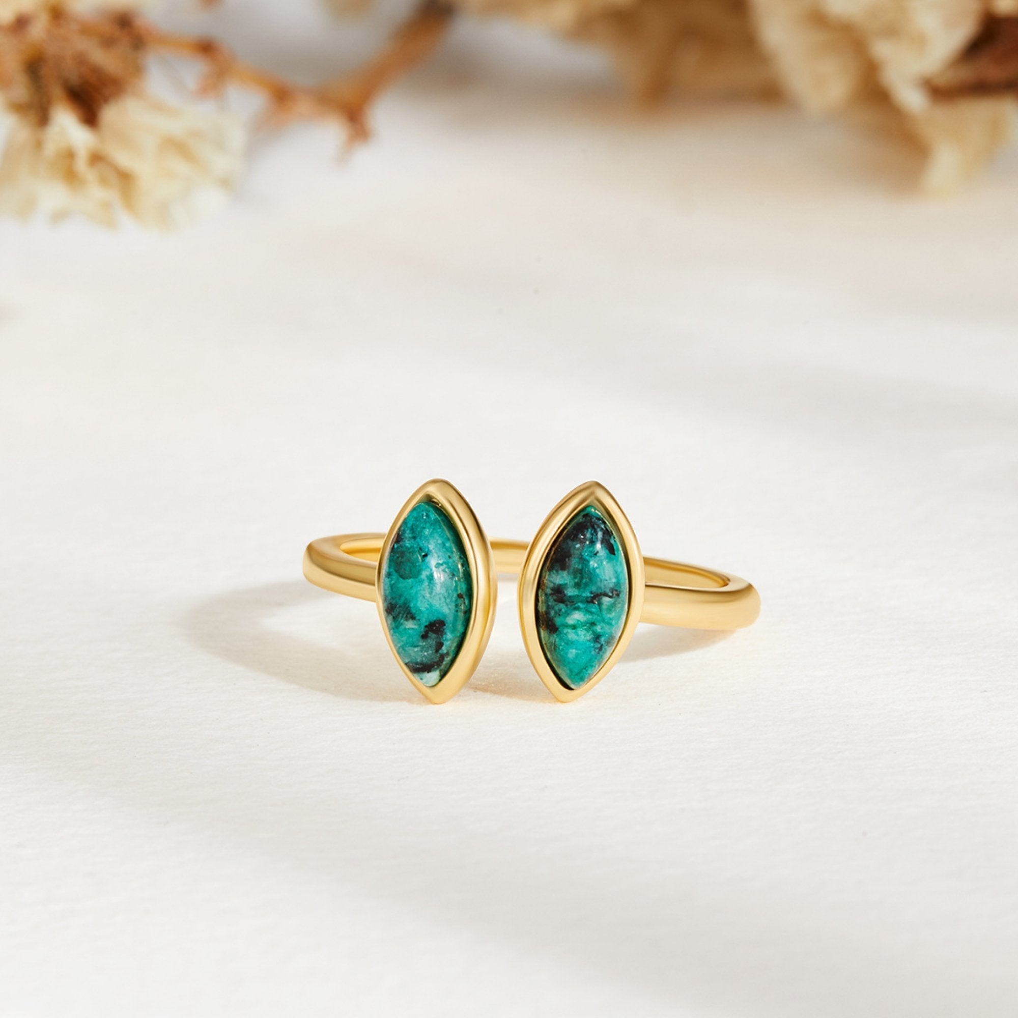 Jade Green Wrap Ring, lying flat on white stone, two marquise green stones in gold