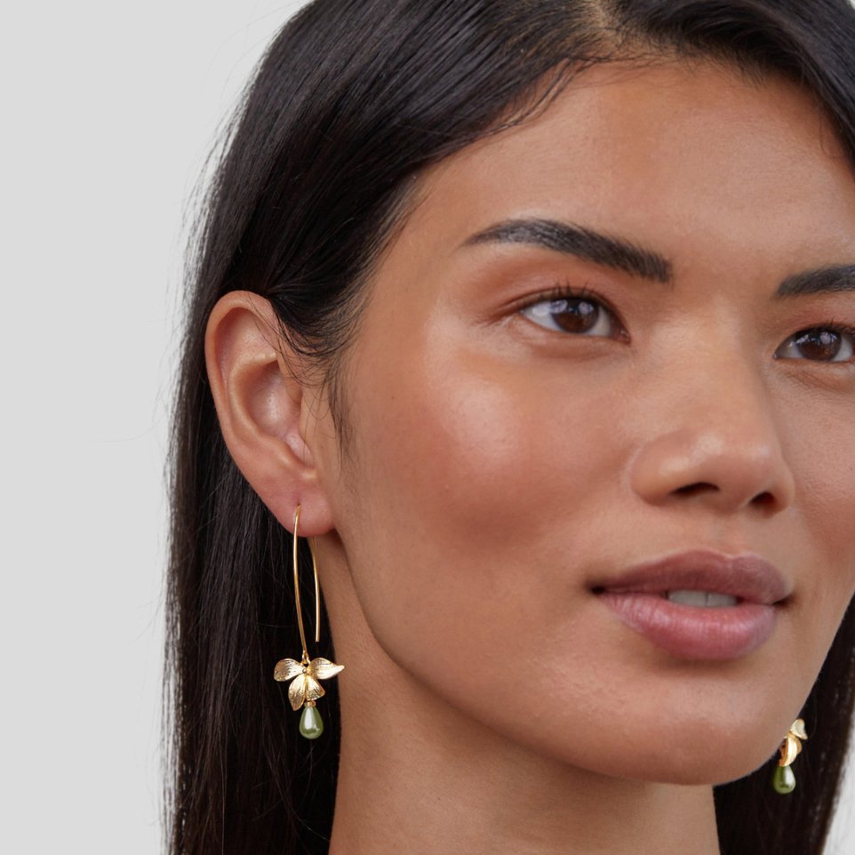 Jade Pearl & Petal Drop Earrings, worn on a model's ear, gold flower with green drop