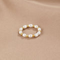 Kai Mini Pearl Ring, ring lying flat on a beige satin cloth, pearls alternating with gold beads
