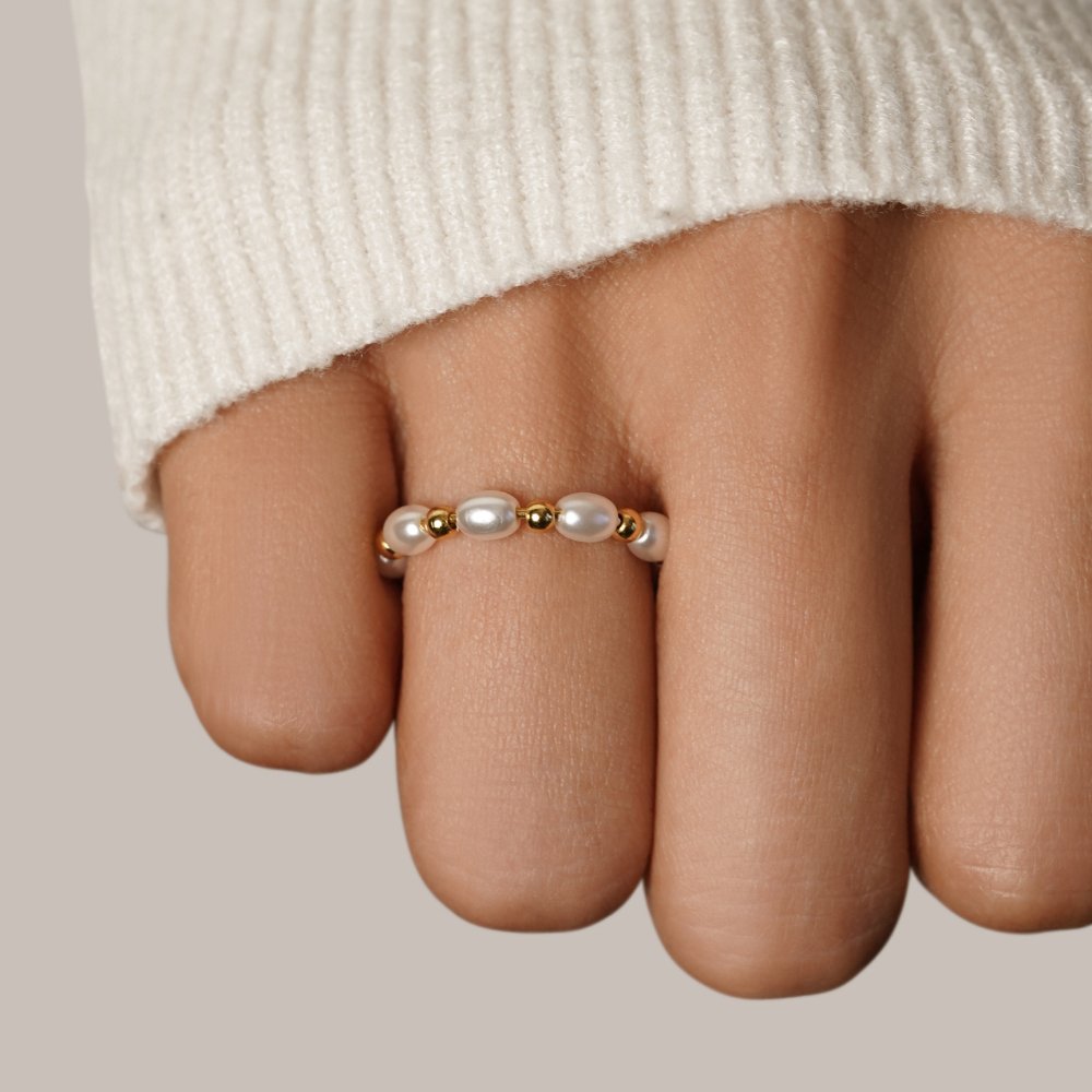 Kai Mini Pearl Ring, worn on a finger with a cream knit sleeve above