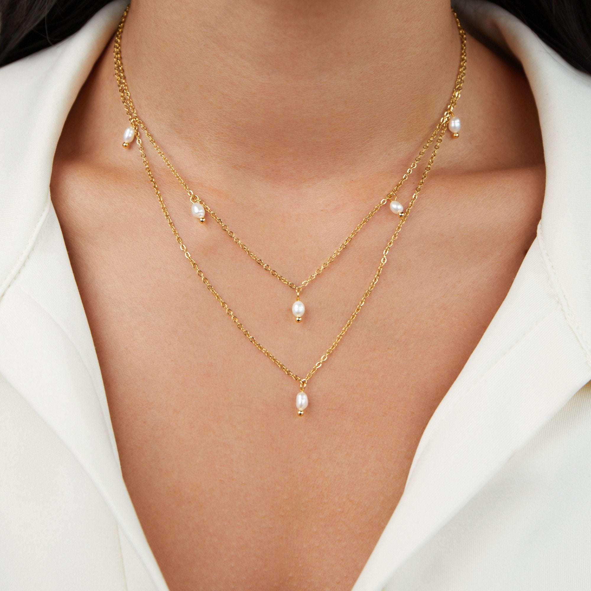 Kayla Pearl Drop Layered Necklace, worn layered on a neck over a white collared top, gold