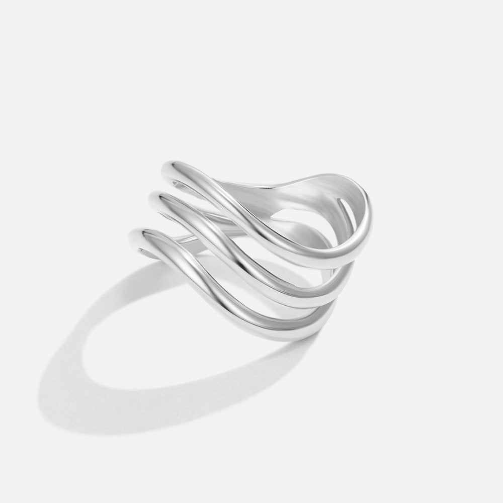 Kiya Layered Silver Ring, polished silver ring with three wavy bands on a plain background