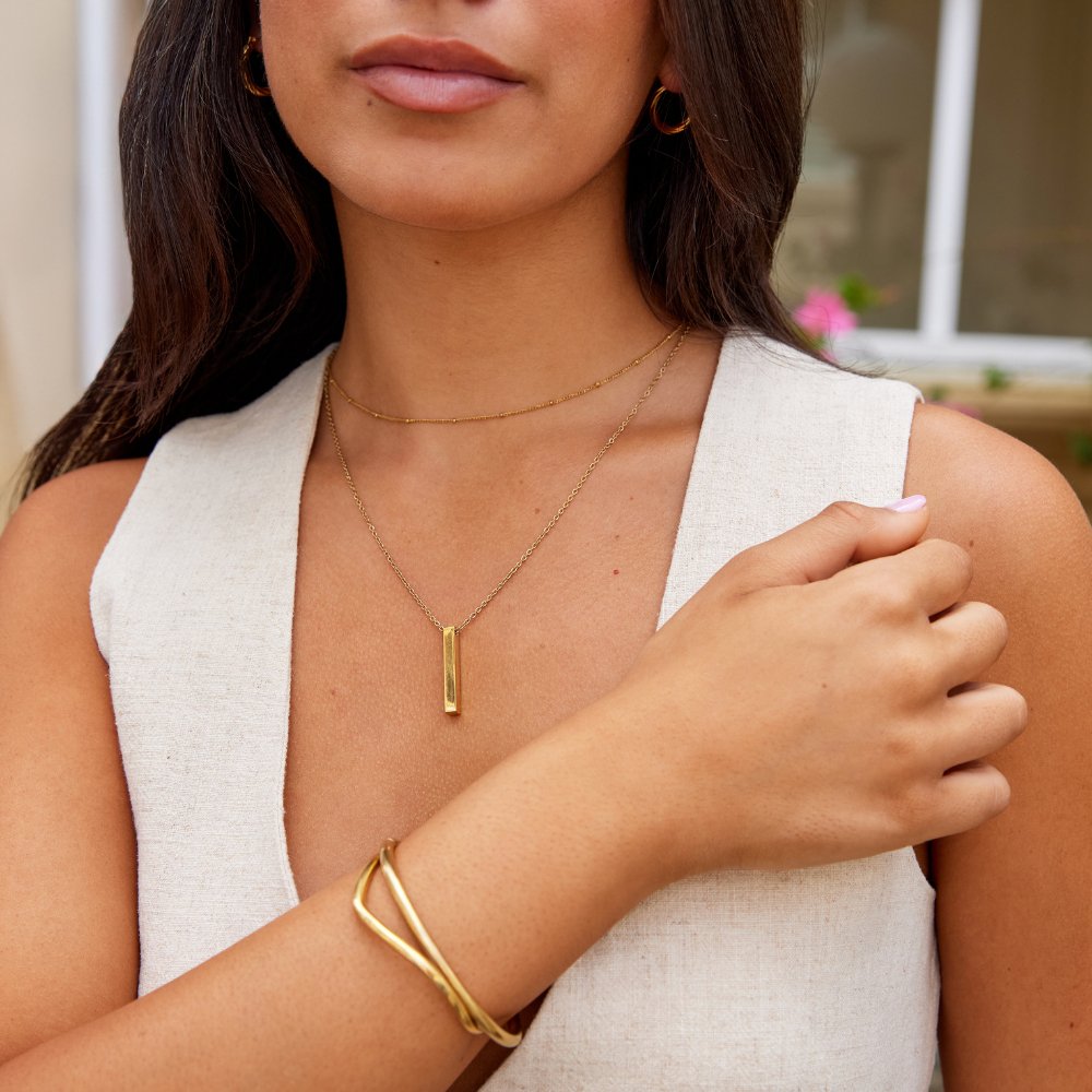 Lala Gold Bar Necklace, worn on a model with gold hoops and a gold bangle