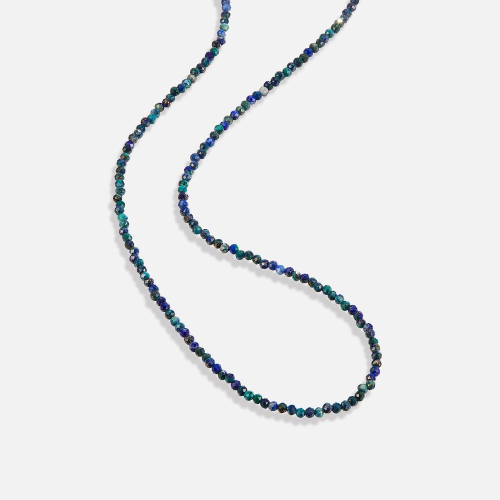 Lapis Lazuli Beaded Stone Necklace, laid out on white background, faceted blue and green beads