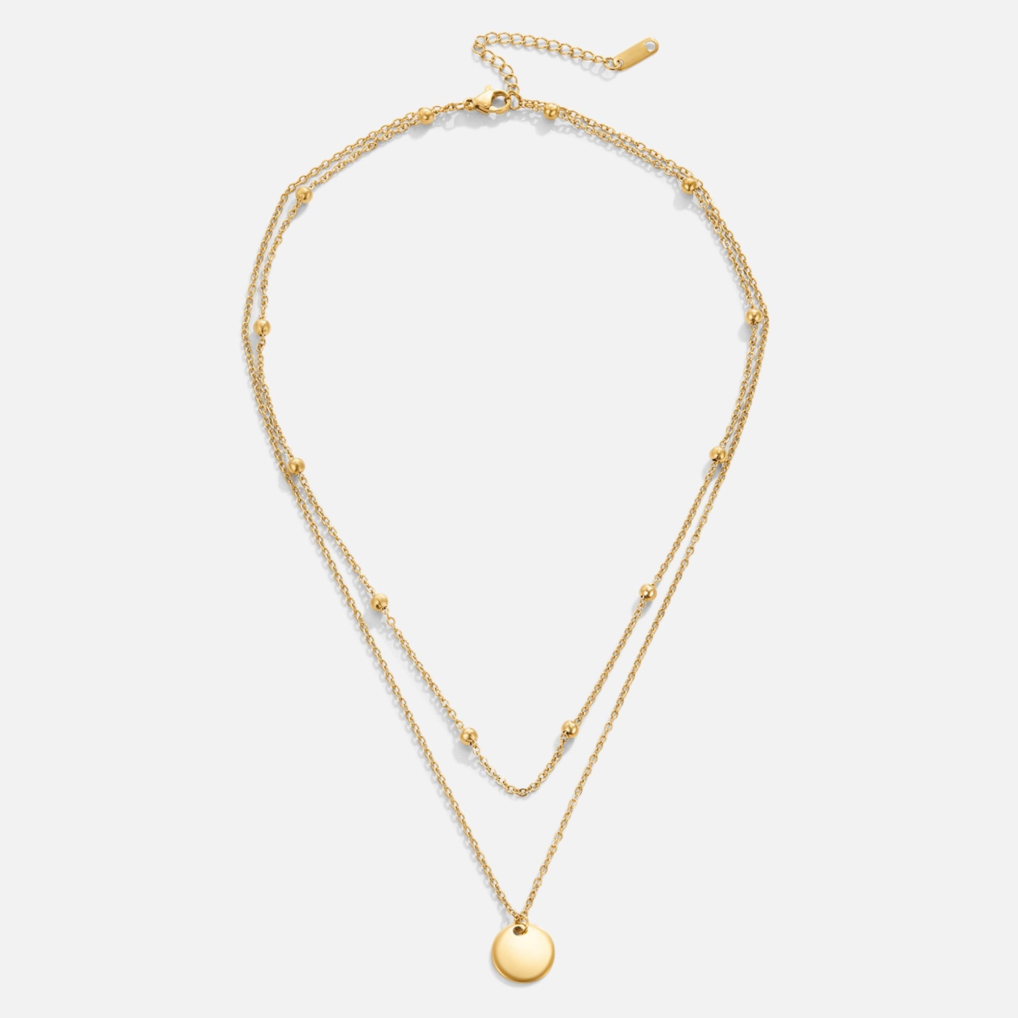 Layered Disc Necklace, flat lay of a gold two-strand necklace with a round disc pendant