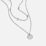 Layered Disc Necklace Silver, flat lay of two silver chains with a round disc pendant