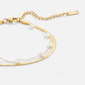 Layered Snake Chain Gold Anklet, close-up of a gold chain with white beads and extender tag