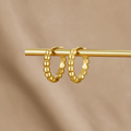 Leona Gold Bead Hoop Earrings, a pair of gold beaded hoops hanging on a gold bar against beige