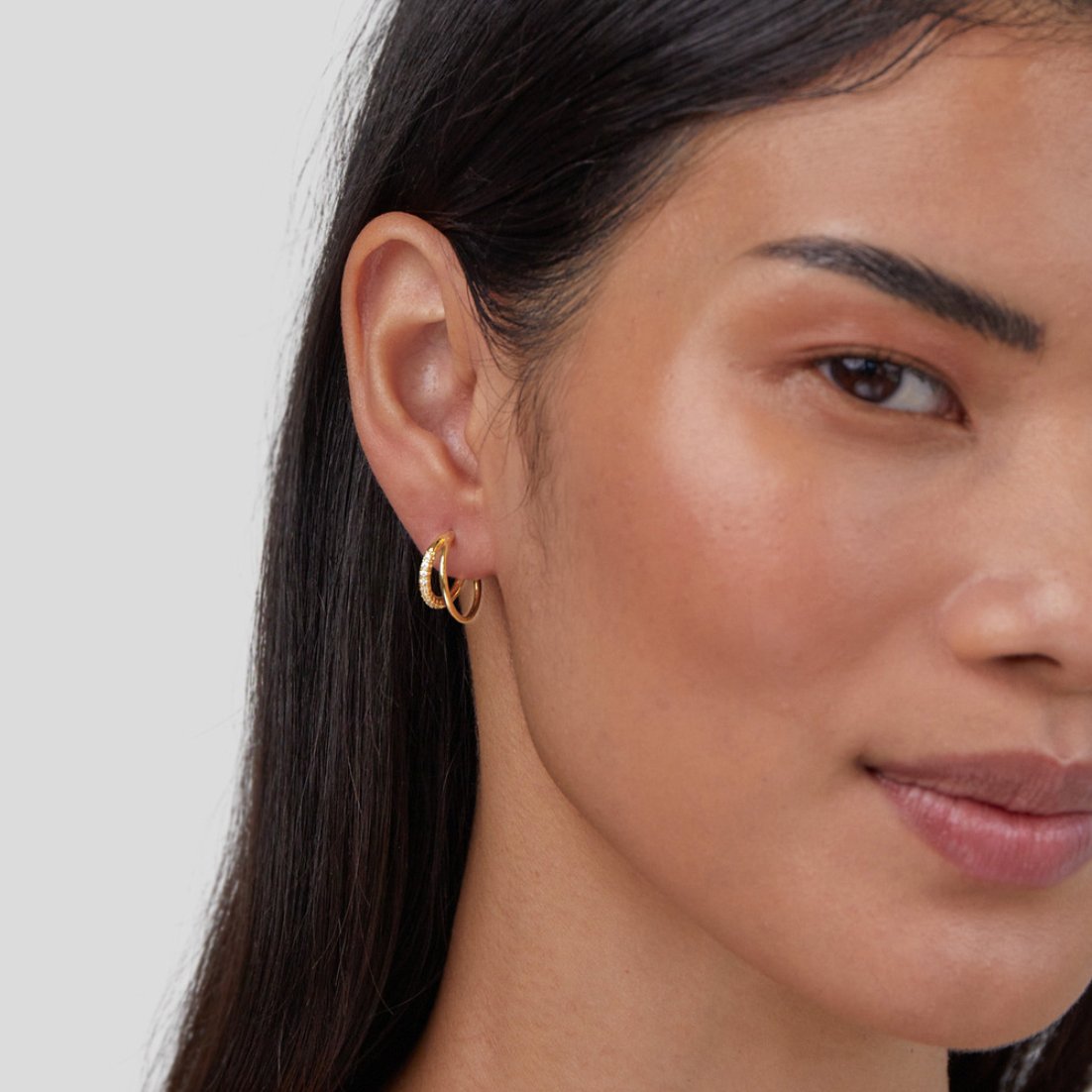 Leyla Crystal Double Hoop Earrings, worn on an ear, close-up of gold hoops with pavé detail