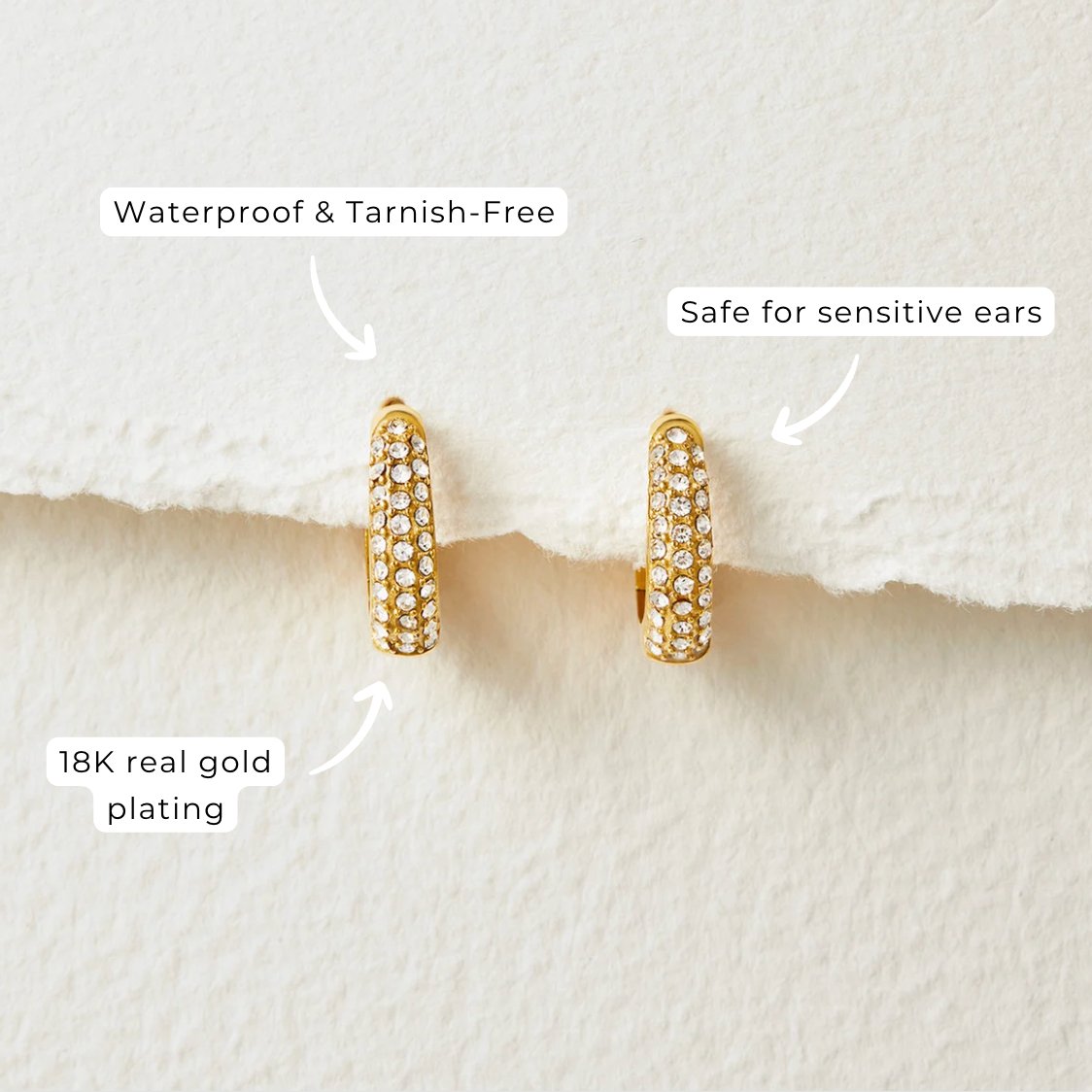 Lily Crystal Hoop Earrings, two gold hoop earrings with crystal pavé on white textured paper