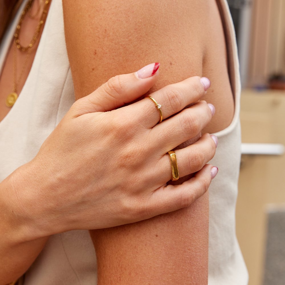 Lola Bar Signet Ring, worn on a hand resting on an arm, with a small stone ring and a chunky band