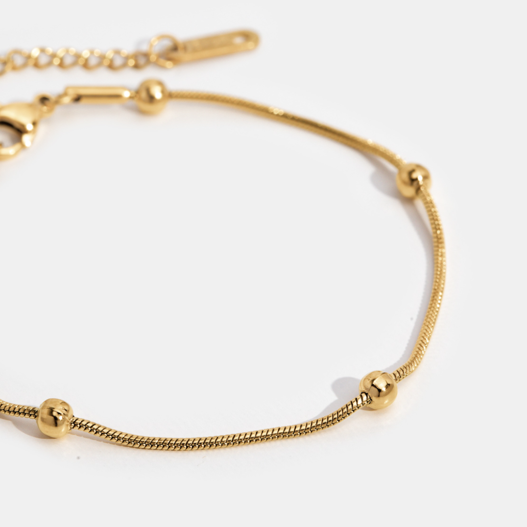 Luna Gold Bead Bracelet, close-up of a gold chain bracelet with evenly spaced round beads on white