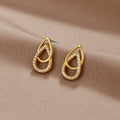 Mara Teardrop Link Earrings, a pair of earrings lying on a beige satin cloth, gold with