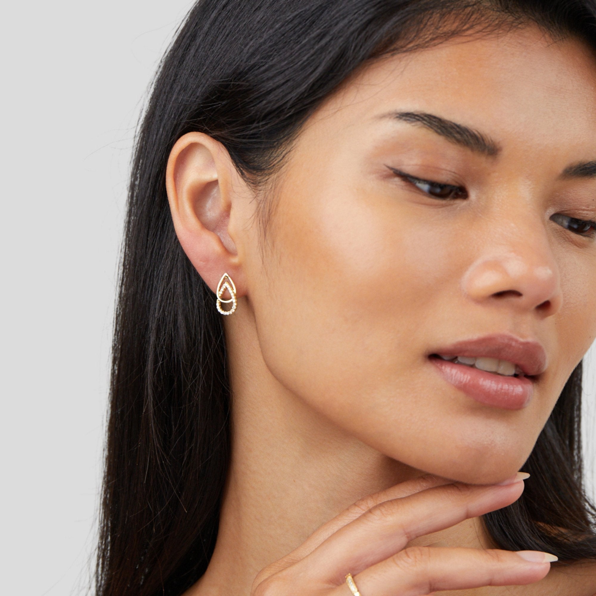 Mara Teardrop Link Earrings, worn on an ear by a model with dark hair, gold with small stones