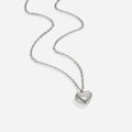 Marina Love Silver Necklace, silver chain necklace laid on white, with a polished heart pendant