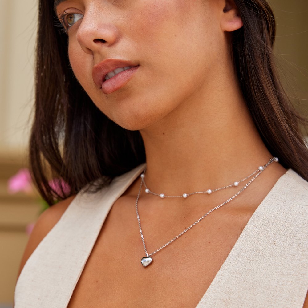 Marina Love Silver Necklace, worn on a model with a cream top, close-up on the neck