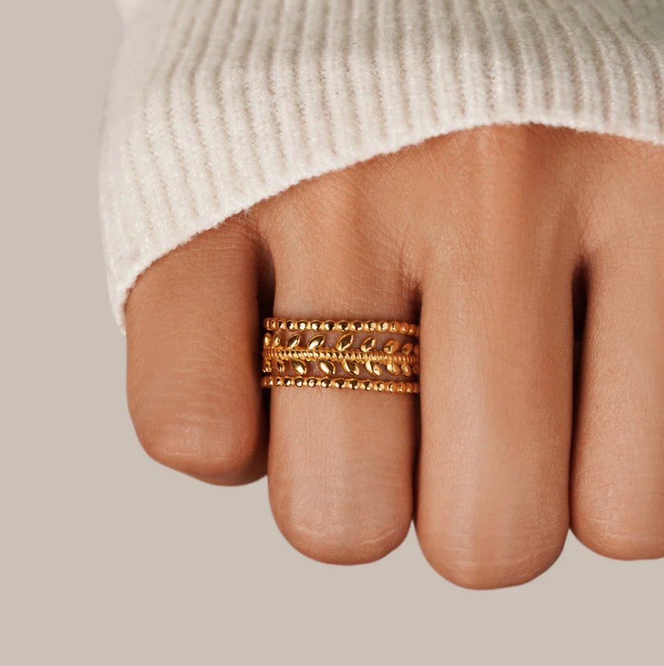 Marissa Layered Gold Leaf Ring, worn on a finger in a cream knit sleeve, three stacked gold bands