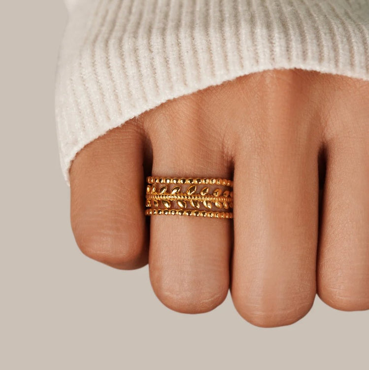 Marissa Layered Gold Leaf Ring, worn on a finger in a cream knit sleeve, three stacked gold bands