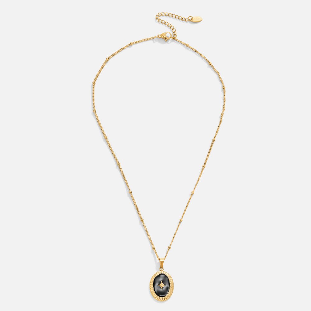 Midnight Star Onyx Necklace, flat lay of gold chain with black oval pendant and star