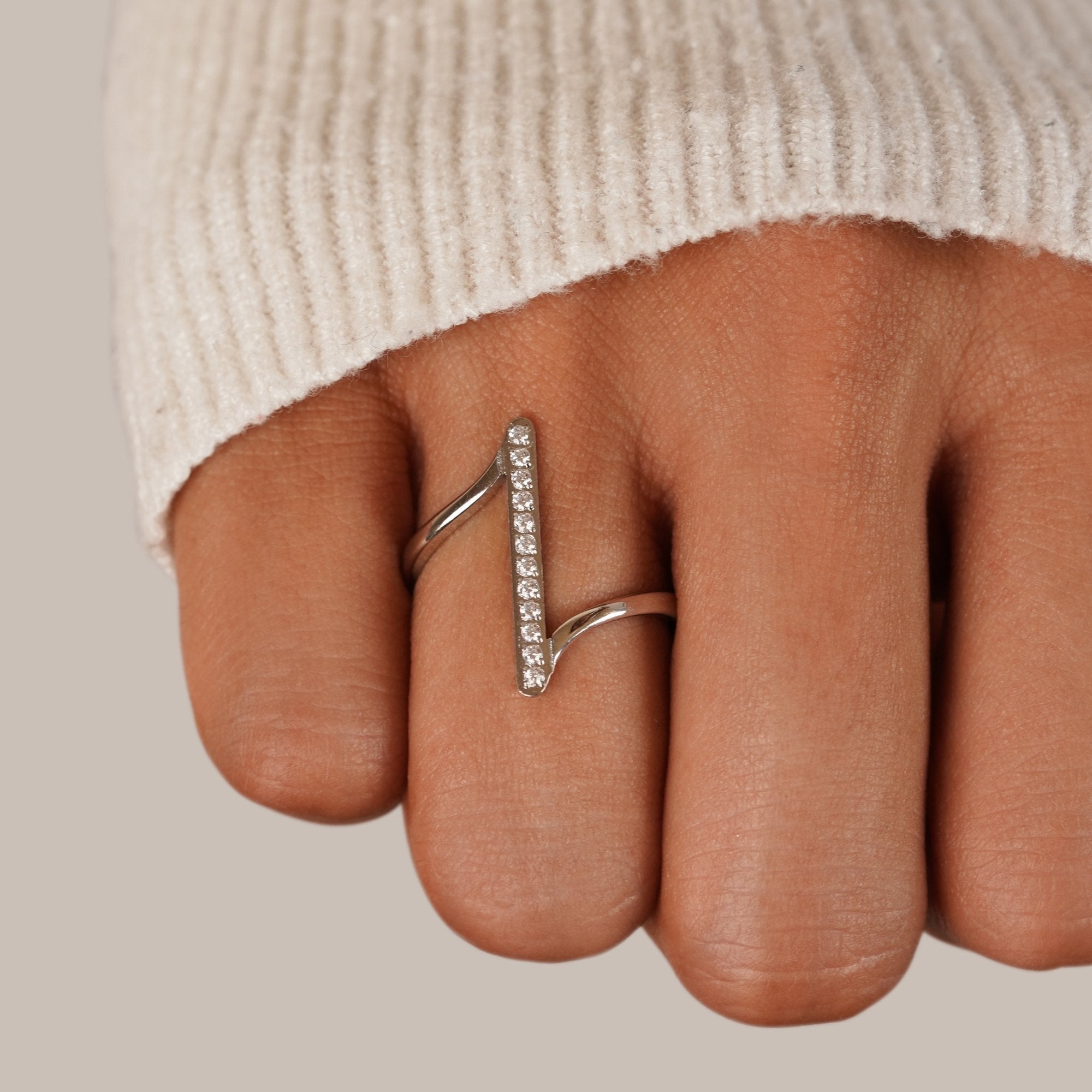 Mila Twisted Silver Ring, worn on a finger with a cream knit sleeve visible