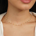 Mila White Bead Necklace, worn at the neck with a white top, gold chain with white beads