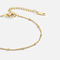 Mira Beaded Gold Anklet, close-up of a gold chain with small beads and a lobster clasp