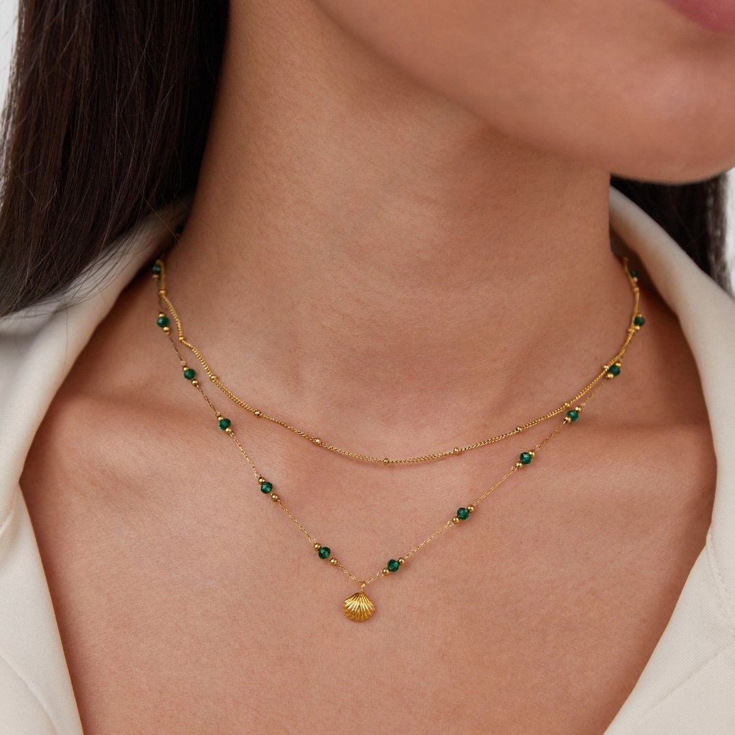 Nerissa Gold Shell & Green Bead Necklace, worn on a neck with layered gold chains and green beads