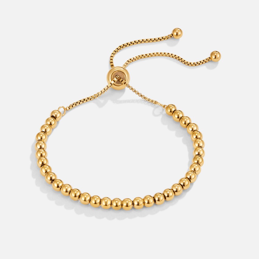 Niloya Beaded Gold Bracelet, flat-lay of a gold bead bracelet with a sliding adjuster clasp